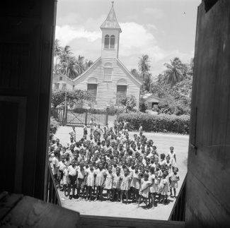 S schoolkinderen van de Hernhuttersschool voor de kerk in Salem, Suriname, 1947  (foto: Willem van de Poll)